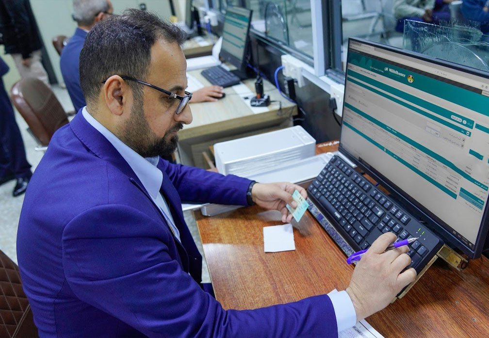 موظف في مديرية المرور العامة العراق يستخدم النظام الإلكتروني الجديد