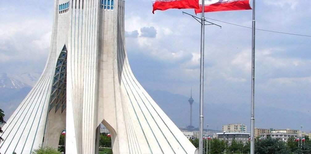 العلمان الإيرانيان أمام برج آزادي في طهران