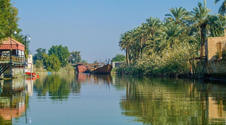 نهر في أبي الخصيب تحيط به بساتين النخيل