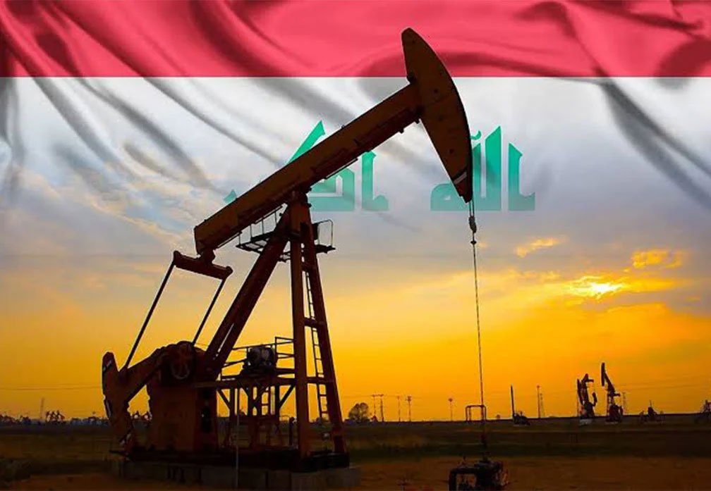 مضخة نفط تعمل في أحد حقول النفط العراقية مع علم العراق في الخلفية