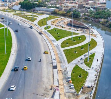 شارع الوفود في البصرة بعد أعمال التطوير والمساحات الخضراء المحاذية للمجرى المائي