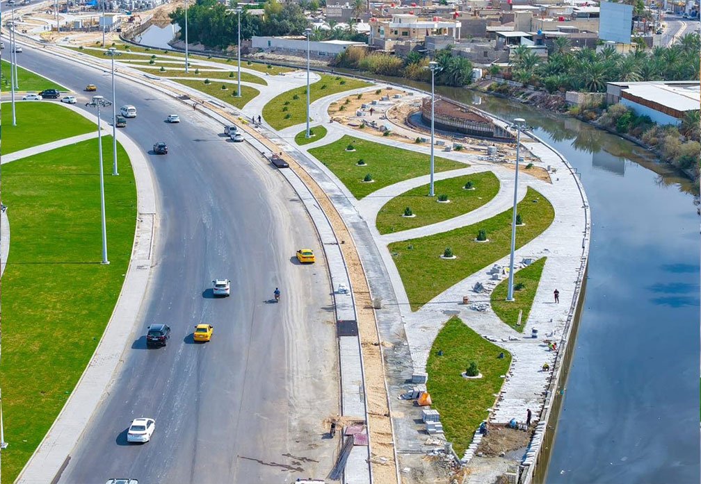 شارع الوفود في البصرة بعد أعمال التطوير والمساحات الخضراء المحاذية للمجرى المائي