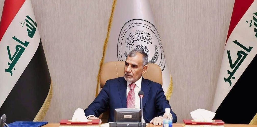 وزير المالية فالح ساري خلال اجتماع رسمي في مقر وزارة المالية بحضور العلم العراقي 