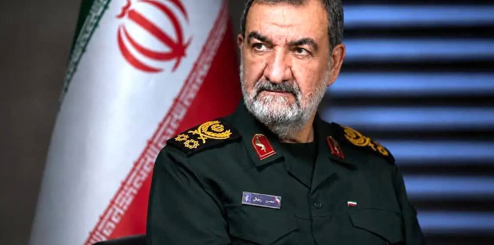 محسن رضائي أمام العلم الإيراني