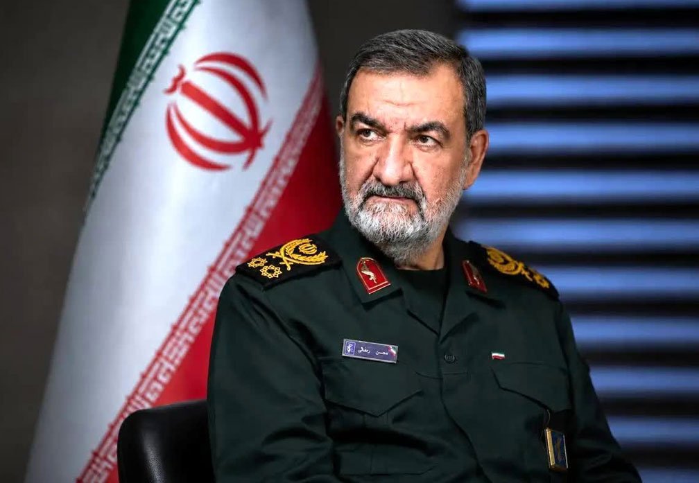 محسن رضائي أمام العلم الإيراني