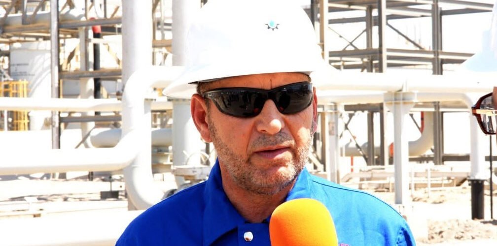 مهندس نفطي داخل منشأة نفطية أثناء إجراء مقابلة صحفية