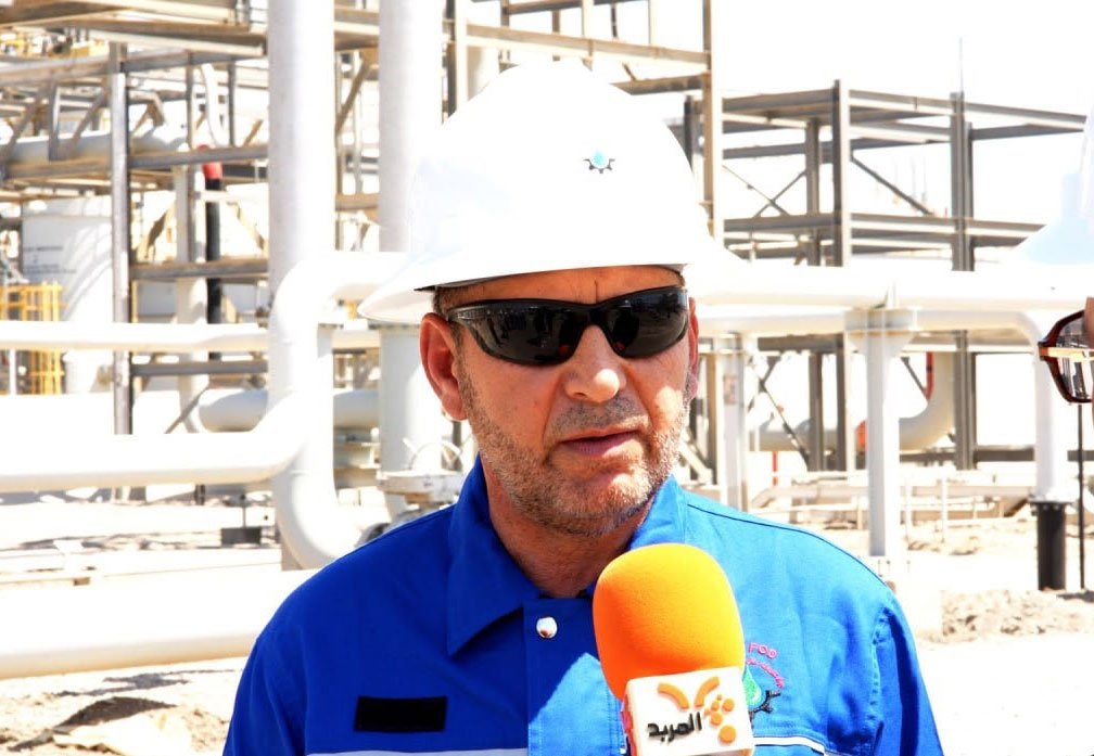مهندس نفطي داخل منشأة نفطية أثناء إجراء مقابلة صحفية