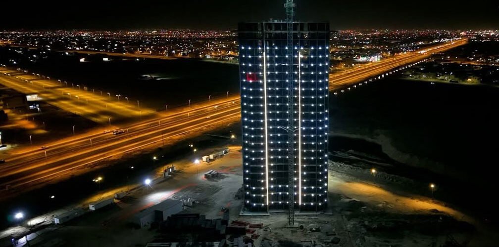 برج مجمع الفرح السكني في البصرة ليلاً أثناء أعمال الإنشاء
