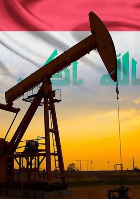 مضخة نفط تعمل في أحد حقول النفط العراقية مع علم العراق في الخلفية